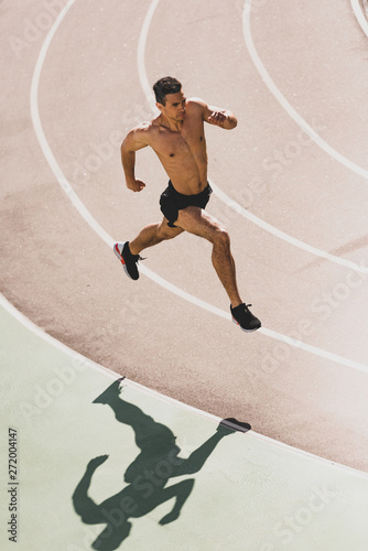 overhead view of mixed race sportsman running at stadium