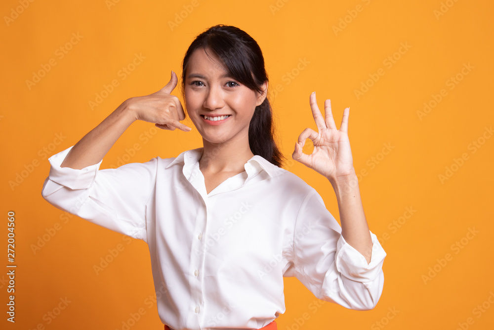 Young Asian woman show with phone gesture and OK sign. Young Asian woman show with phone gesture and OK sign.