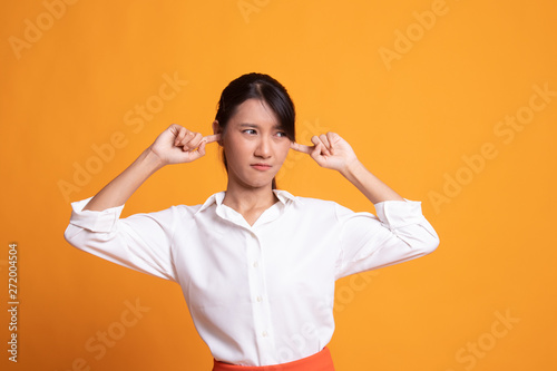 Young Asian woman block both ears with fingers.