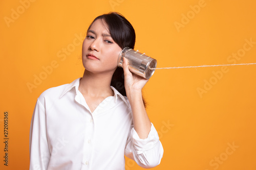 Young Asian woman with tin can phone.