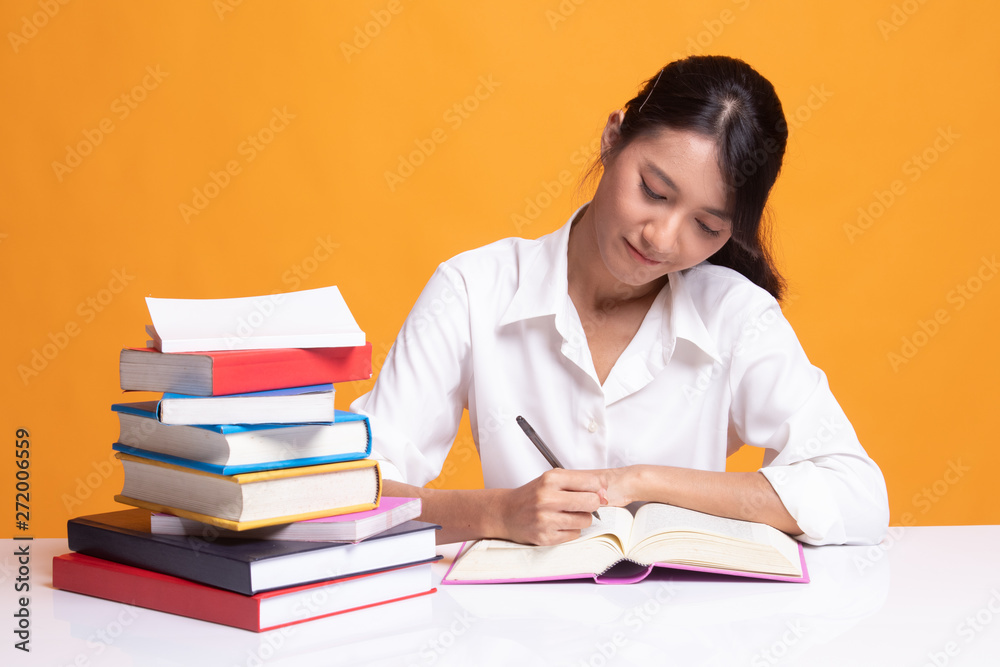 Young Asian woman read a book with books on table. Young Asian woman read a book with books on table.