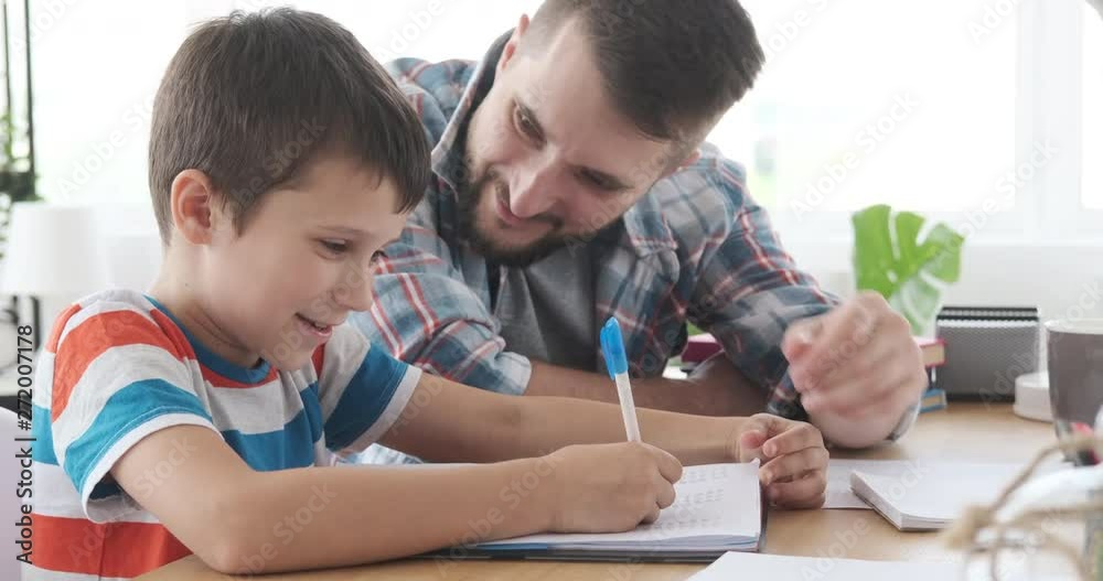 Man with his son having fun doing homework in his notebook Man with his son having fun doing homework in his notebook