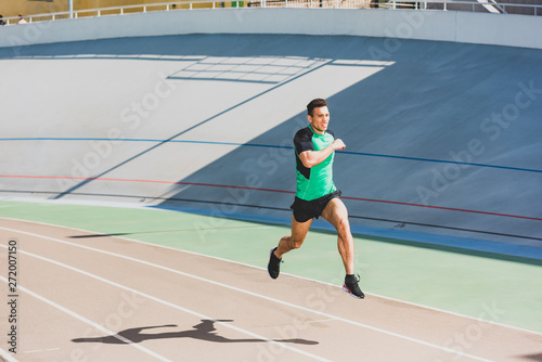 full length view of mixed race sportsman running at stadium