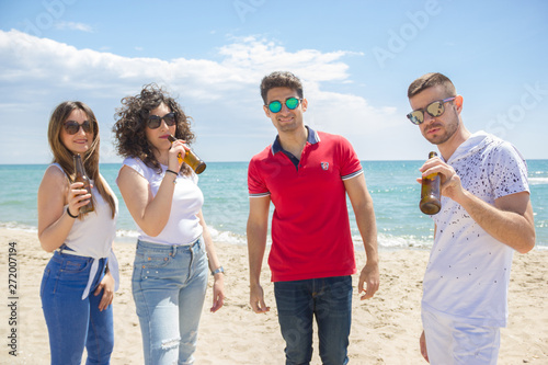 Group of friends close up with sunglasses celebrate the Summer at beach with beer
