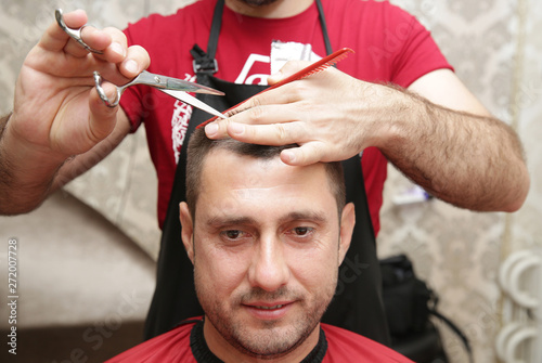 Close-up, hairdresser cutting hair with scissors. Concept for barbershop.