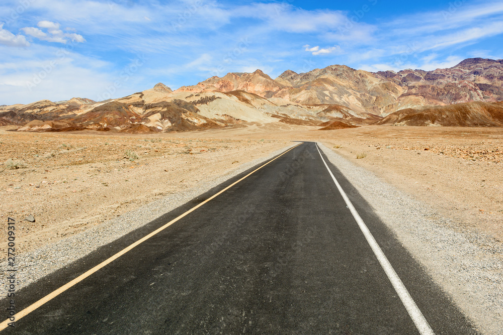 Desert road leading through Death Valley National Park, Artist's Drive road, California USA.