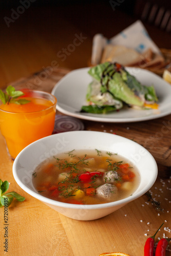 Summer light soup with vegetables and meatballs for the first course and vegan spring rolls for the second course as a part of healthy mid day meal