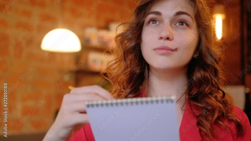 Artist inspiration. Beautiful focused young woman sketching in cafe in her notepad Artist inspiration. Beautiful focused young woman sketching in cafe in her notepad