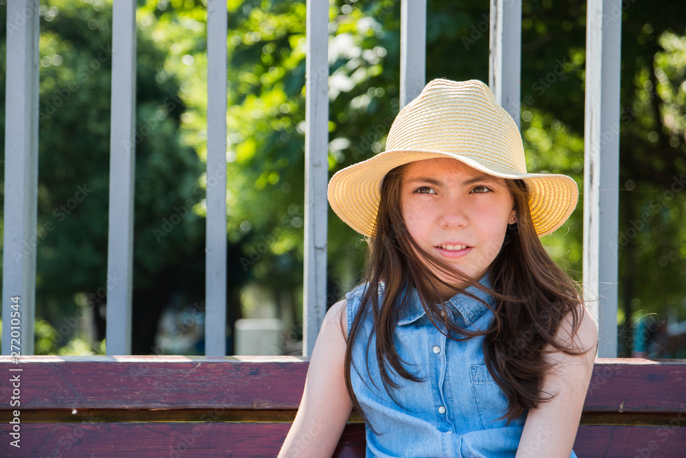 portrait of beautiful girl sitting on Park bench in hot summer. summer vacation