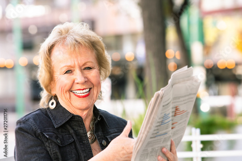 Happy Womn Reacting to Newspaper Story photo