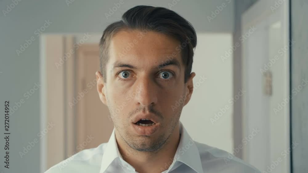 Portrait of young man is surprised and takes off his glasses in shock. He is worried about seeing