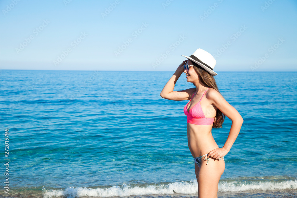 Beautiful young woman in sexy bikini standing at sea beach Beautiful young woman in sexy bikini standing at sea beach