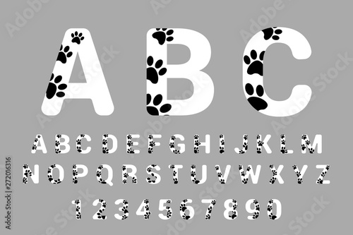 Fototapeta Naklejka Na Ścianę i Meble -  Font typography with animal paw prints. Isolated Alphabet with pet foot prints. White calligraphy and numbers with black dog paws.