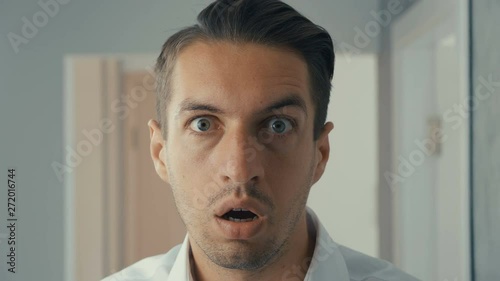 Young man is shocked and surprised. A man in surprise shoots glasses and looks at the camera in surprise. photo