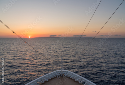 Small cruise liner sailing across the ocean as dawn starts to light the sky © steheap