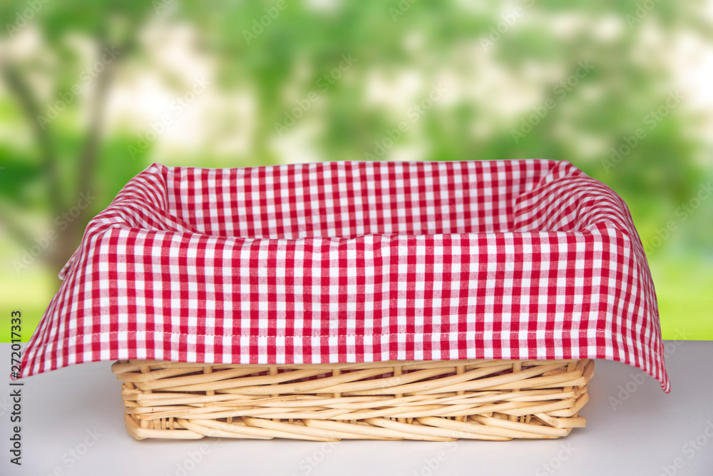  Wicker basket with a red cloth inside on a white table