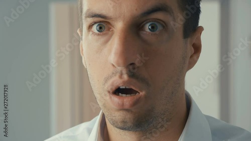 Portrait of young man is surprised and takes off his glasses in shock. He is worried about seeing