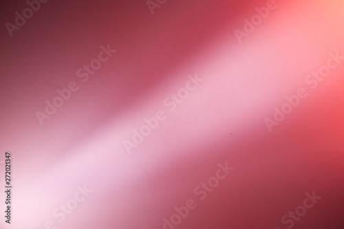 Diagonal light pink ray of light on a pink and dark pink background