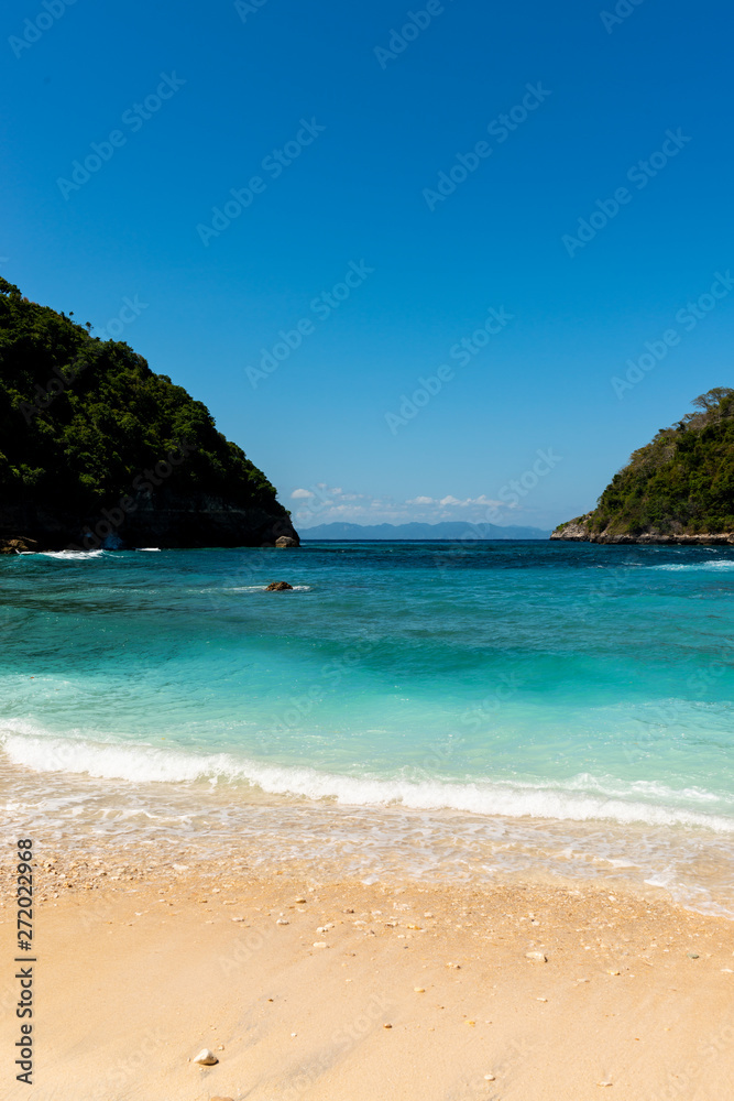 Fototapeta premium View of tropical beach, sea rocks and turquoise ocean, blue sky. Atuh Beach, Nusa Penida, Indonesia.