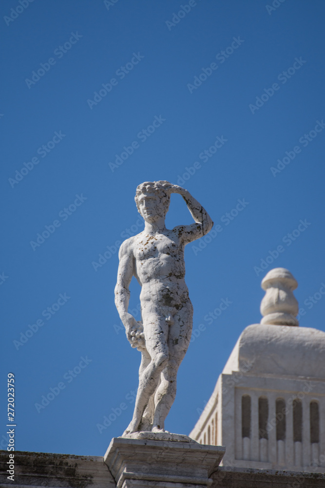 Statue in a row in St Mark's Square roof, Venice,march, 2019