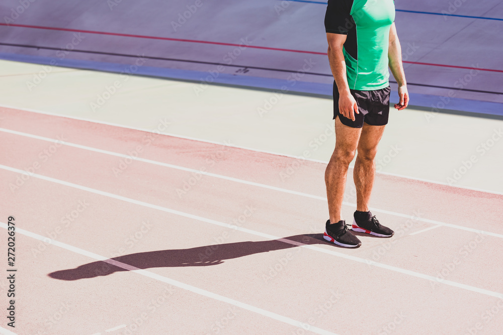 cropped view of sportsman in sportswear standing at stadium