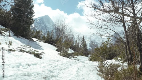 Mountain trail in the valley with a view of the mountains at the beginning of spring. Tatra mountains, Zeleneho plesa valley, Maly Kezmarsky stit photo