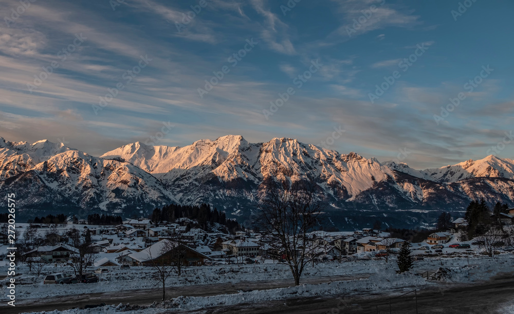 Panoramic view on Austrian village Tulfes near Innsbruck and Heiliger Apostel Thomas church in winter day at sunset.