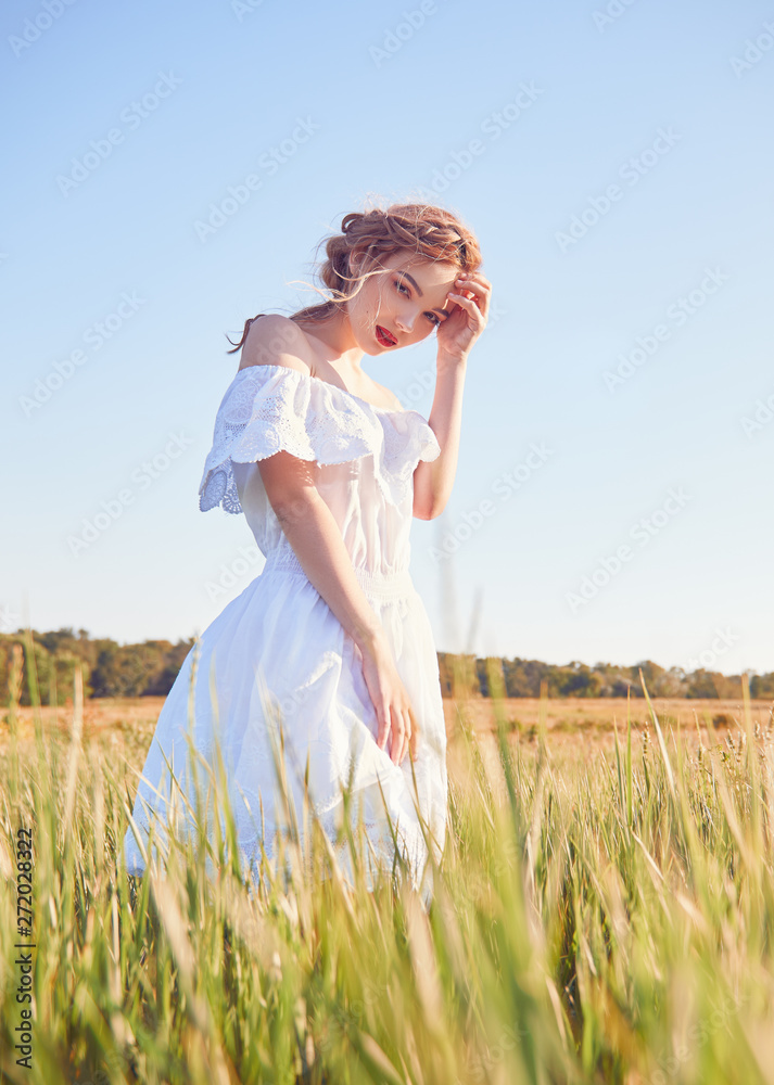 Portrait of pretty young sad woman wearing white dress in meadow Portrait of pretty young sad woman wearing white dress in meadow