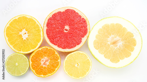 cut pieces of different citrus fruits on white background