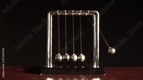Newton's cradle over black background FRONT VIEW