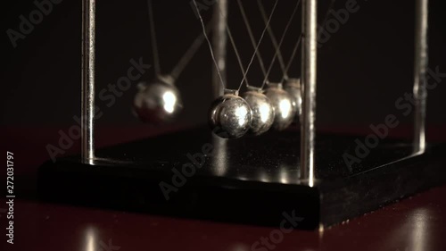 Newton's cradle over black background, view from one side  4K photo