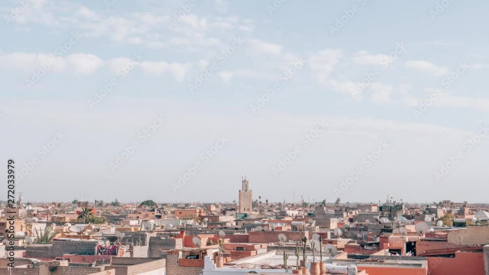 Time lapse at daytime overlooking the cityscape of Marrakesh Morocco with blue skies white clouds above traditional building Time lapse at daytime overlooking the cityscape of Marrakesh Morocco with blue skies white clouds above traditional building