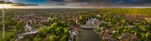 Dramatic aerial panoramic view of the beautiful town of Marlow in Buckinghamshire UK, captured after a rain storm, with a rainbow on the horizon