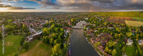 Dramatic aerial panoramic view of the beautiful town of Marlow in Buckinghamshire UK, captured after a rain storm, with a rainbow on the horizon