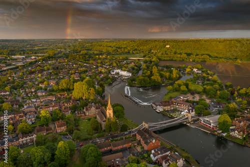 Dramatic aerial panoramic view of the beautiful town of Marlow in Buckinghamshire UK, captured after a rain storm, with a rainbow on the horizon photo