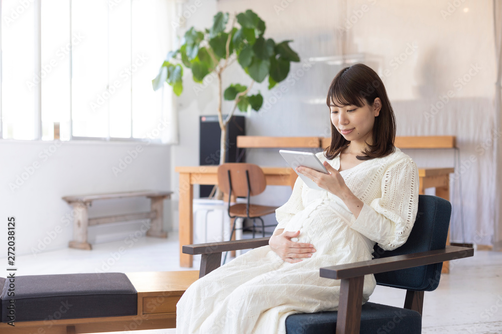室内でくつろぐ妊婦 タブレット 室内でくつろぐ妊婦 タブレット