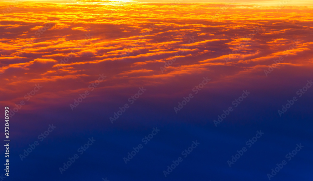 Obraz premium Beautiful sunset. Colorful dramatic sky at sunset. Layered rain clouds. Bright blue orange background. The texture of the sunset. The sky at sunset as the sea and lava.