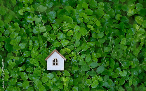 toy wooden house in green grass background. Symbol of happiness, family, Mortgage, Real estate concept. Eco Friendly House, Eco home. Home sweet home. top view. copy space