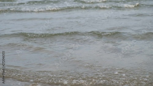Slow motion, close up female walking along sandy beach background of ocean waves, in thailand