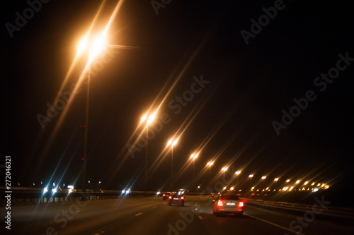 black night road highway with yellow lights and cars