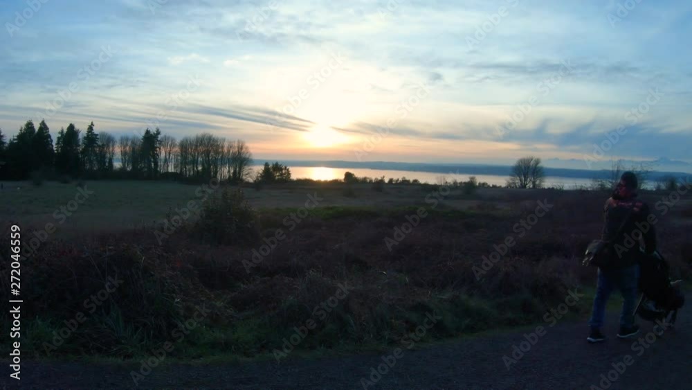 Man Walking Baby in Stroller at Sunset Waterfront Forest Park Winter Man Walking Baby in Stroller at Sunset Waterfront Forest Park Winter