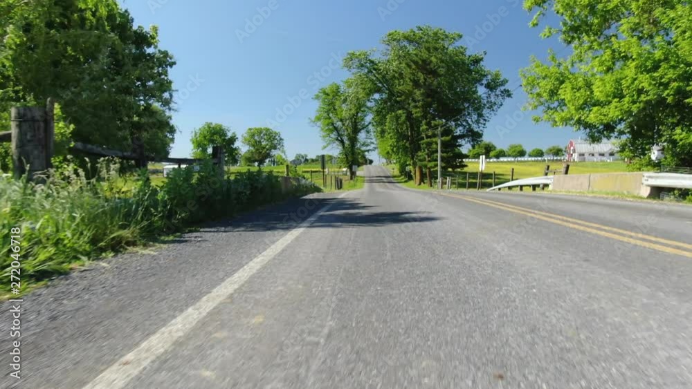 Glide shot down sunny country road through Pennsylvania farmlands 4k Glide shot down sunny country road through Pennsylvania farmlands 4k