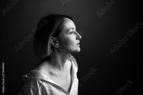 Dramatic black and white portrait of a beautiful woman on a dark background