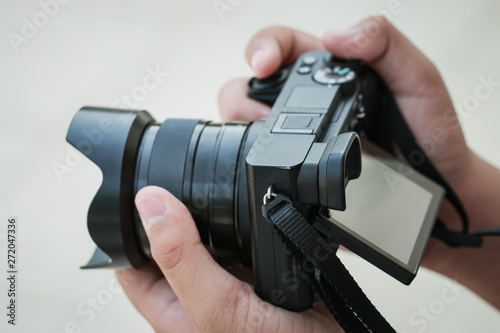 Production movie video concept : Professional videographer or photographer holding mirrorless camera shooting take photo or video for recording at outdoor. Process media films concept
