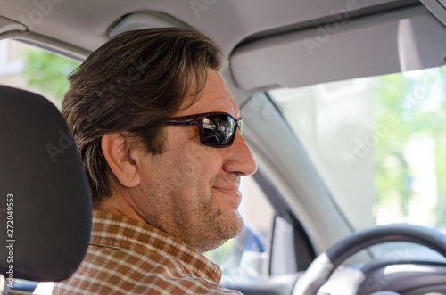 smiling man in sunglass driving car.