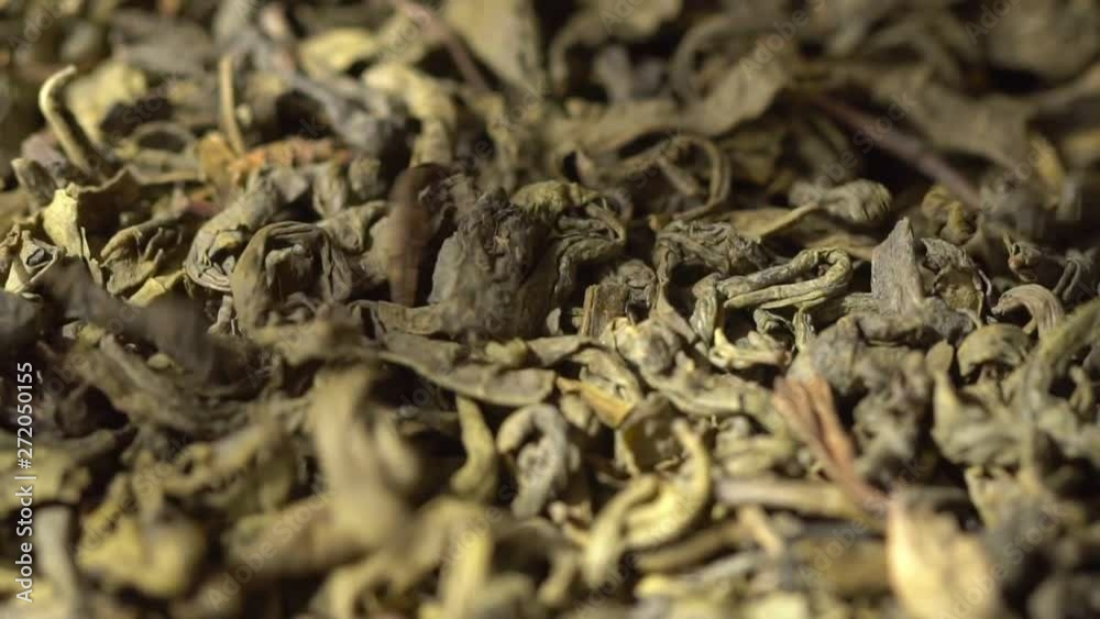 SLOW MOTION: Tea leaves fall on a pile of a green tea - Macro shot. Beautiful view. SLOW MOTION: Tea leaves fall on a pile of a green tea - Macro shot. Beautiful view.