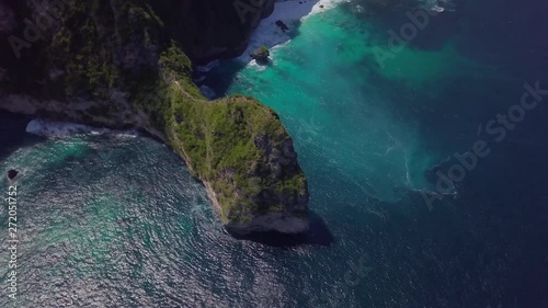 AERIAL TILT UP REVEAL: Drone reveals gorgeous cliff face of iconic kelingking beach at high tide in Nusa Penida, Indonesia photo