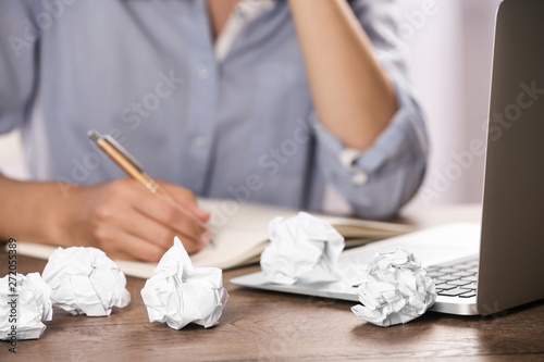 Woman working at table with crumpled paper, closeup. Generating idea