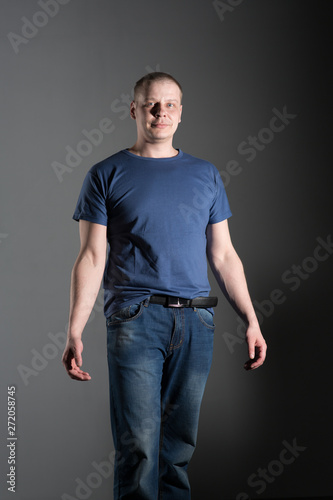 a man in blue jeens and t-shirt photo