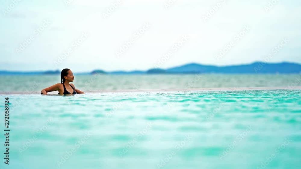 Beautiful woman relaxing in swimming pool in luxury tourist resort Beautiful woman relaxing in swimming pool in luxury tourist resort